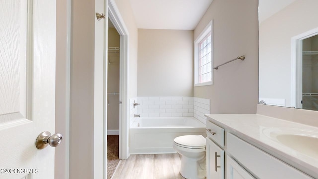 bathroom with a bathing tub, vanity, and toilet