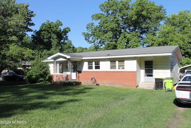 view of front of home featuring a front yard, covered porch, and brick siding