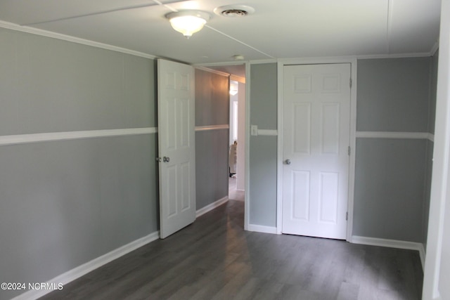 unfurnished bedroom with dark wood-style floors, visible vents, crown molding, and baseboards