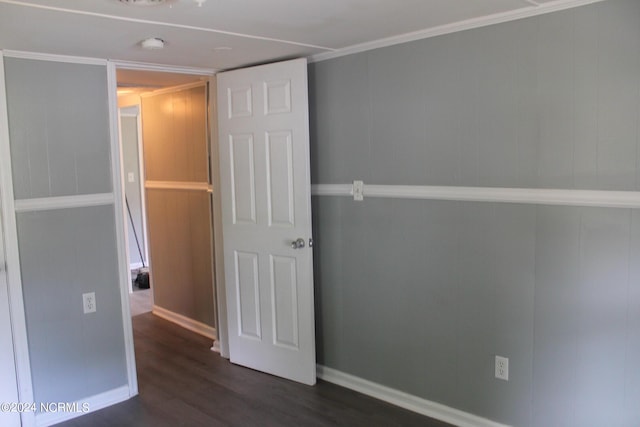 spare room with baseboards and dark wood-style flooring