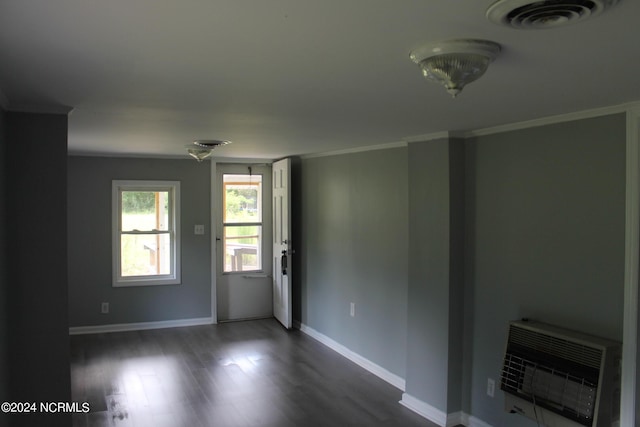 unfurnished living room with baseboards, visible vents, dark wood-style floors, heating unit, and crown molding