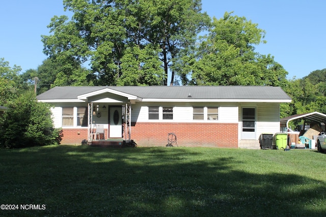 view of front facade with a carport, brick siding, and a front yard