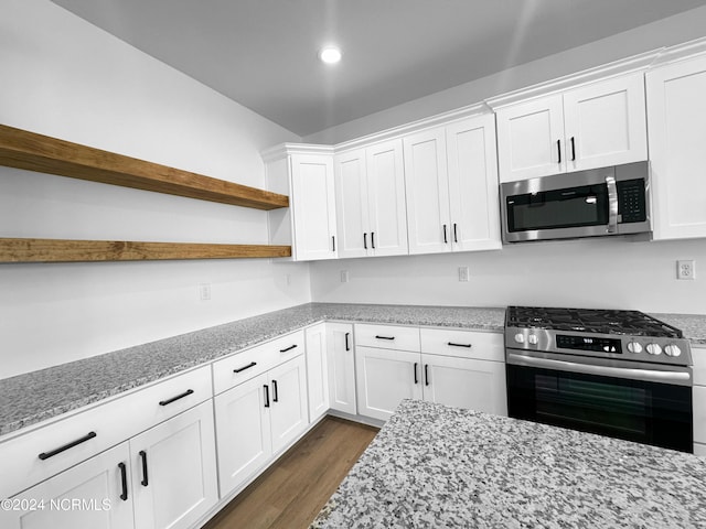 kitchen featuring white cabinets, dark wood finished floors, appliances with stainless steel finishes, light stone counters, and open shelves