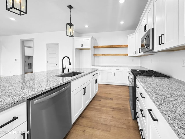 kitchen featuring appliances with stainless steel finishes, light wood-type flooring, a sink, and recessed lighting