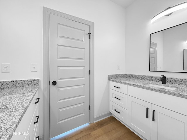 bathroom featuring baseboards, wood finished floors, and vanity