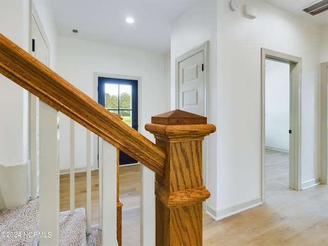 stairway with recessed lighting, visible vents, baseboards, and wood finished floors