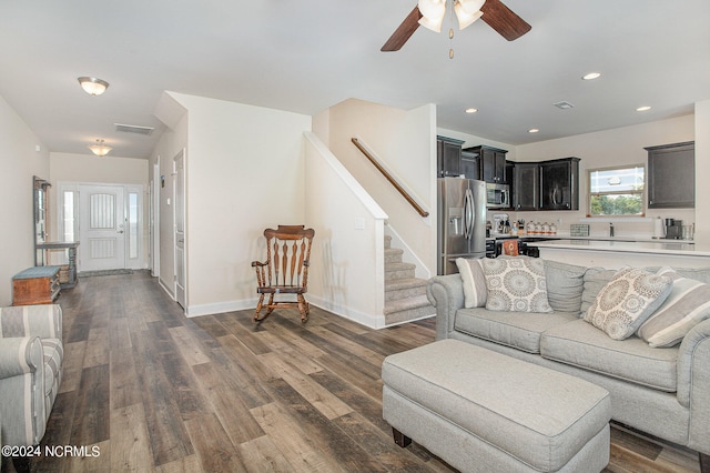 living room with stairway, visible vents, dark wood-type flooring, and recessed lighting