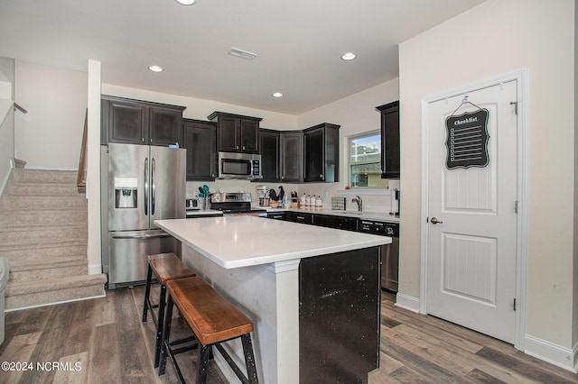 kitchen with appliances with stainless steel finishes, dark wood-style flooring, visible vents, and a center island