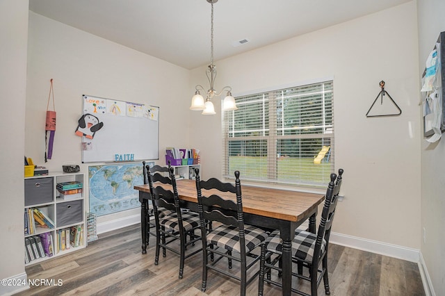 dining space with an inviting chandelier, baseboards, visible vents, and wood finished floors