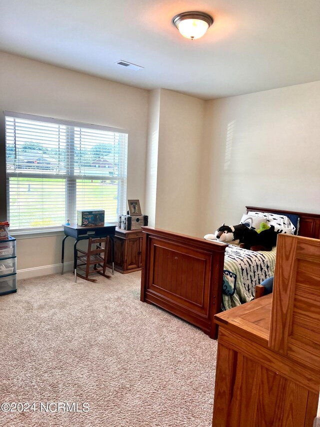 bedroom with light colored carpet, visible vents, and baseboards