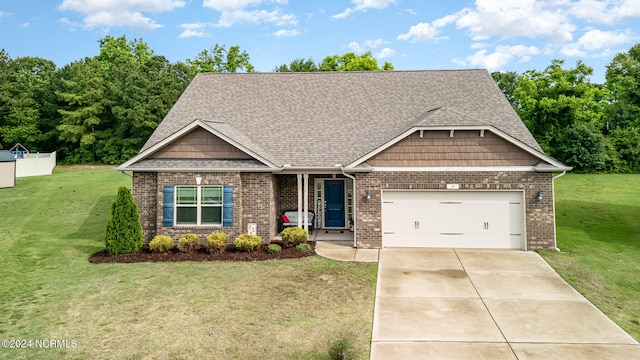 craftsman house featuring an attached garage, driveway, a front lawn, and brick siding