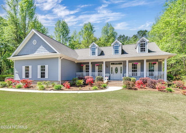 new england style home with covered porch and a front yard