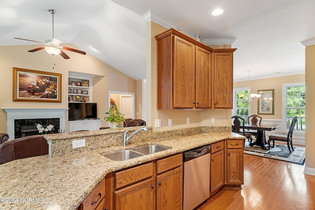 kitchen featuring light wood-type flooring, stainless steel dishwasher, sink, built in features, and a premium fireplace