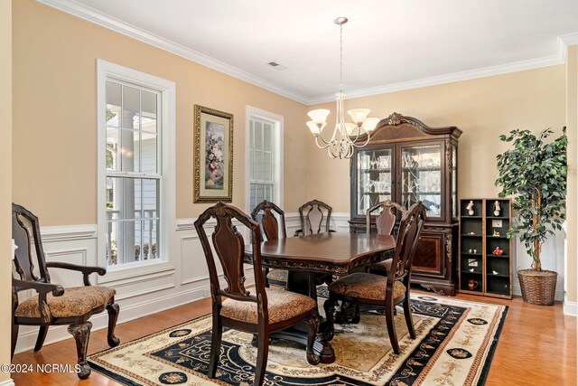 dining area with plenty of natural light, light wood-type flooring, and ornamental molding