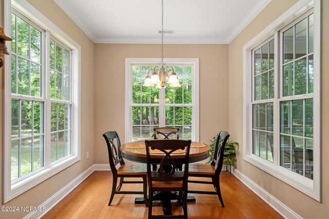 dining space featuring a notable chandelier, plenty of natural light, and light wood-type flooring