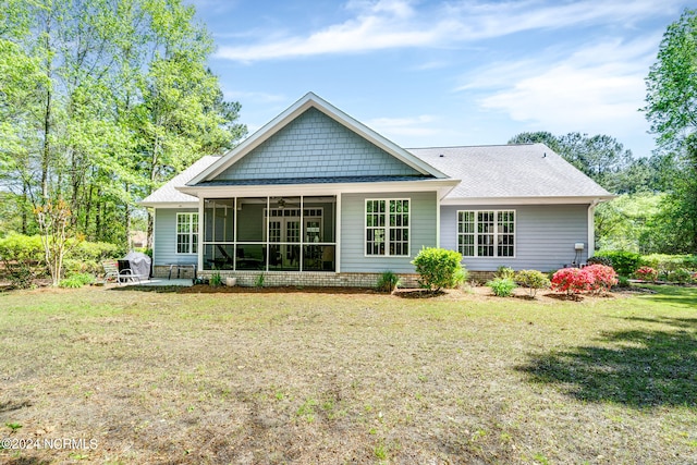 rear view of property with a lawn and a sunroom