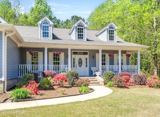 227 October Glory Dr, Wallace, NC 28466 - view of front of home featuring a porch, a shingled roof, and a front lawn