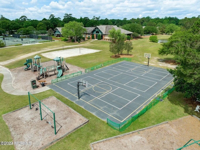 view of property's community with a playground, basketball hoop, and a yard