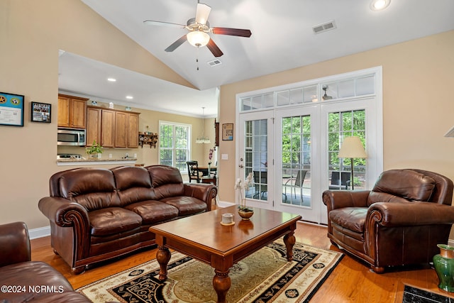 living room with light wood-type flooring, vaulted ceiling, and ceiling fan