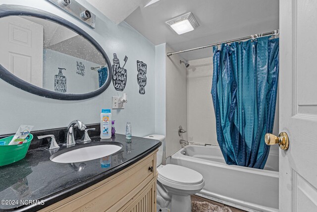 full bathroom featuring shower / bath combination with curtain, toilet, and vanity