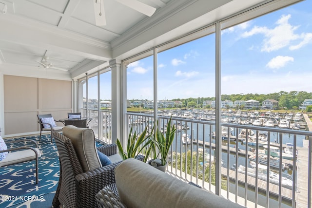 sunroom / solarium featuring a water view and ceiling fan