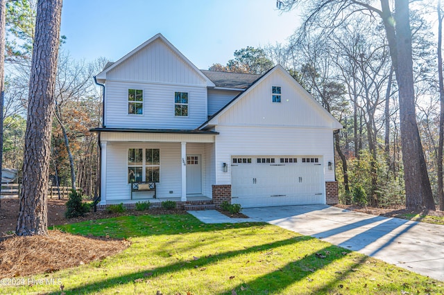 view of front facade featuring covered porch, a front yard, and a garage