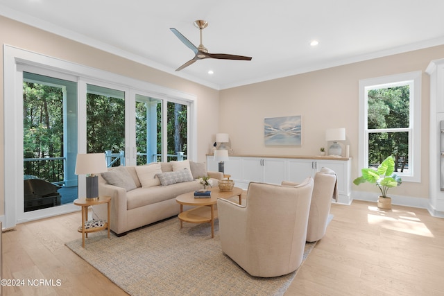 living room with ceiling fan, crown molding, and light hardwood / wood-style floors