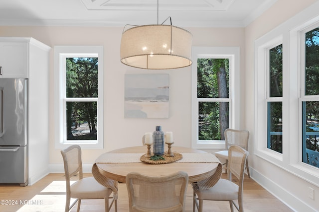 dining room with plenty of natural light, light wood-type flooring, and ornamental molding