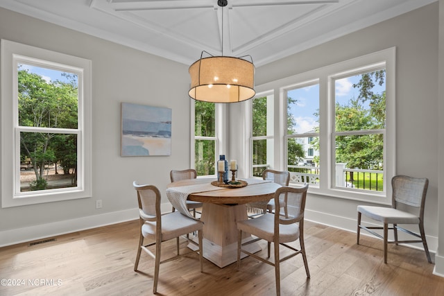 dining space featuring light wood-type flooring and crown molding