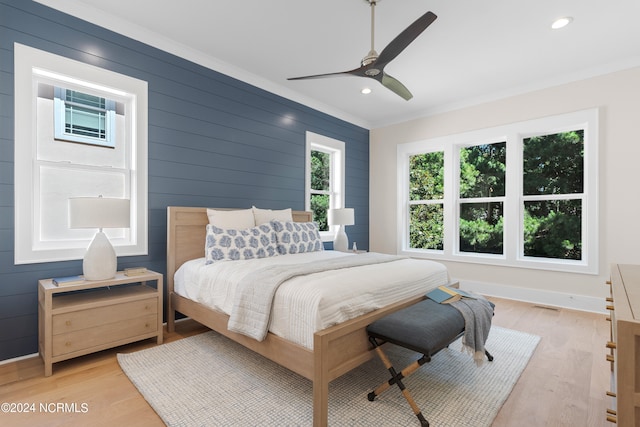 bedroom with ceiling fan, ornamental molding, and light hardwood / wood-style flooring