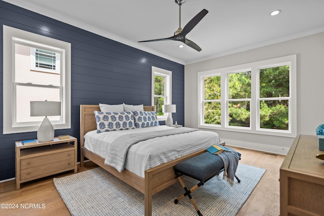 bedroom featuring ceiling fan, light wood-type flooring, and crown molding