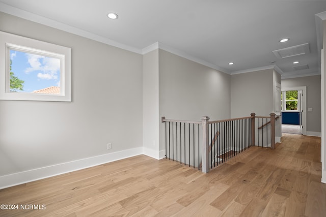 empty room featuring light wood-type flooring and crown molding