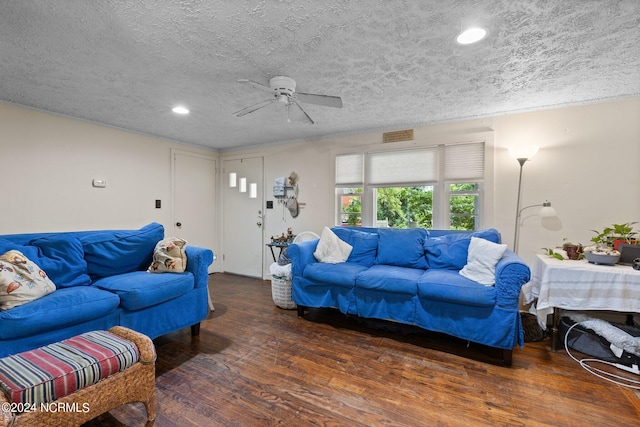 living room featuring ceiling fan, dark hardwood / wood-style flooring, and a textured ceiling