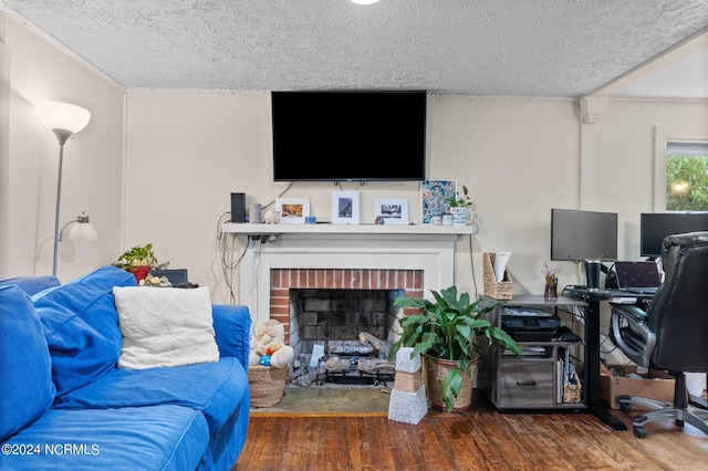 living room with a textured ceiling, a fireplace, and wood-type flooring