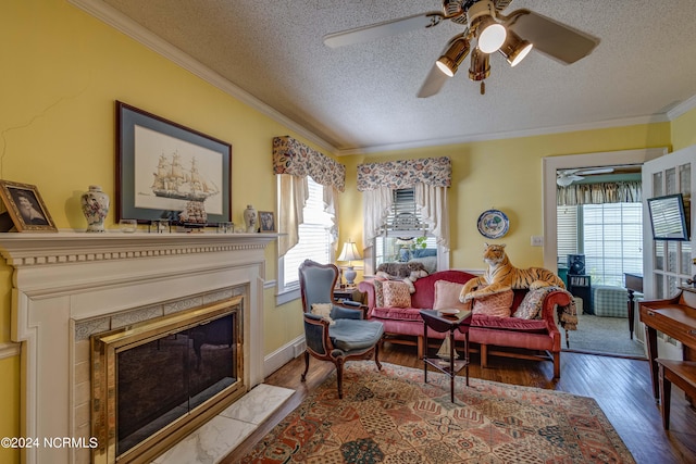 living room with crown molding, wood finished floors, a wealth of natural light, and a glass covered fireplace