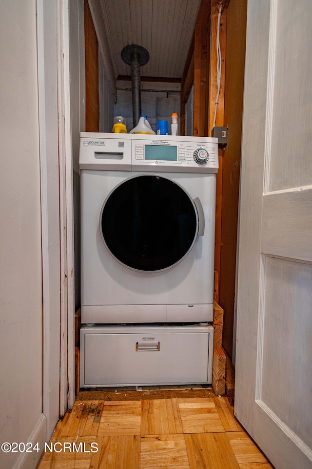 clothes washing area with hardwood / wood-style floors and washer / dryer