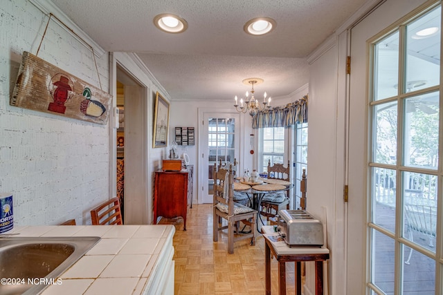 dining room with a textured ceiling, recessed lighting, a chandelier, and crown molding
