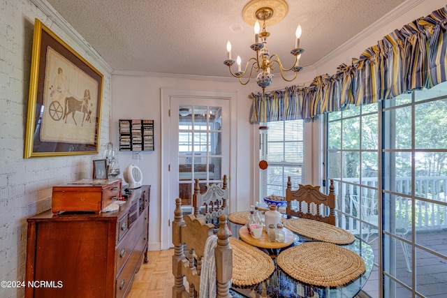 dining room with a textured ceiling, ornamental molding, and an inviting chandelier