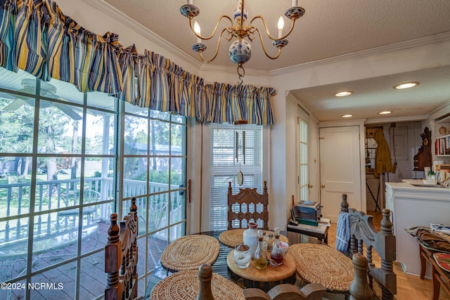 dining area featuring a textured ceiling, ornamental molding, recessed lighting, and an inviting chandelier