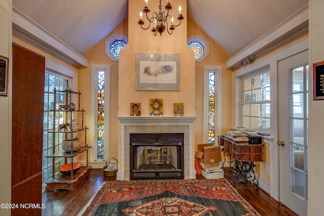 living area featuring lofted ceiling, french doors, a tiled fireplace, and wood finished floors