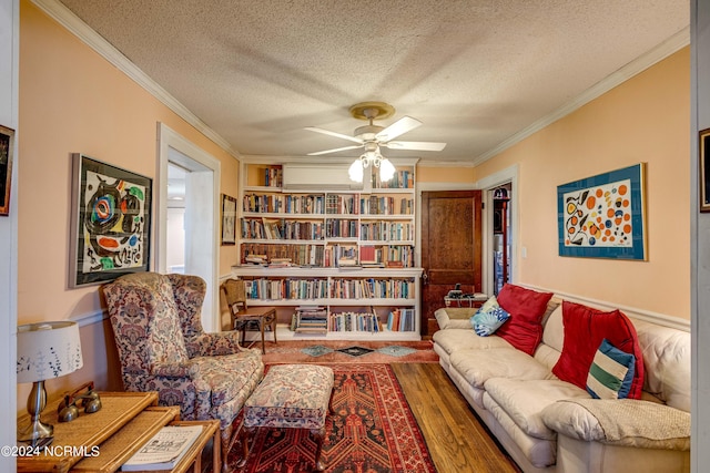 sitting room featuring a ceiling fan, ornamental molding, and a textured ceiling
