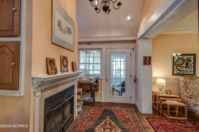 entryway with crown molding and a tiled fireplace