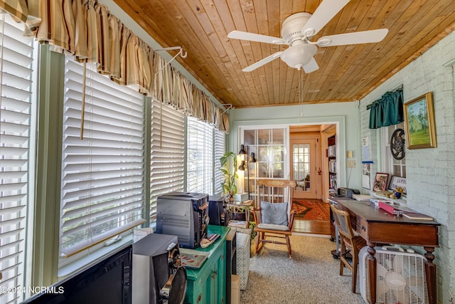interior space featuring a wood stove, brick wall, wood ceiling, and a ceiling fan