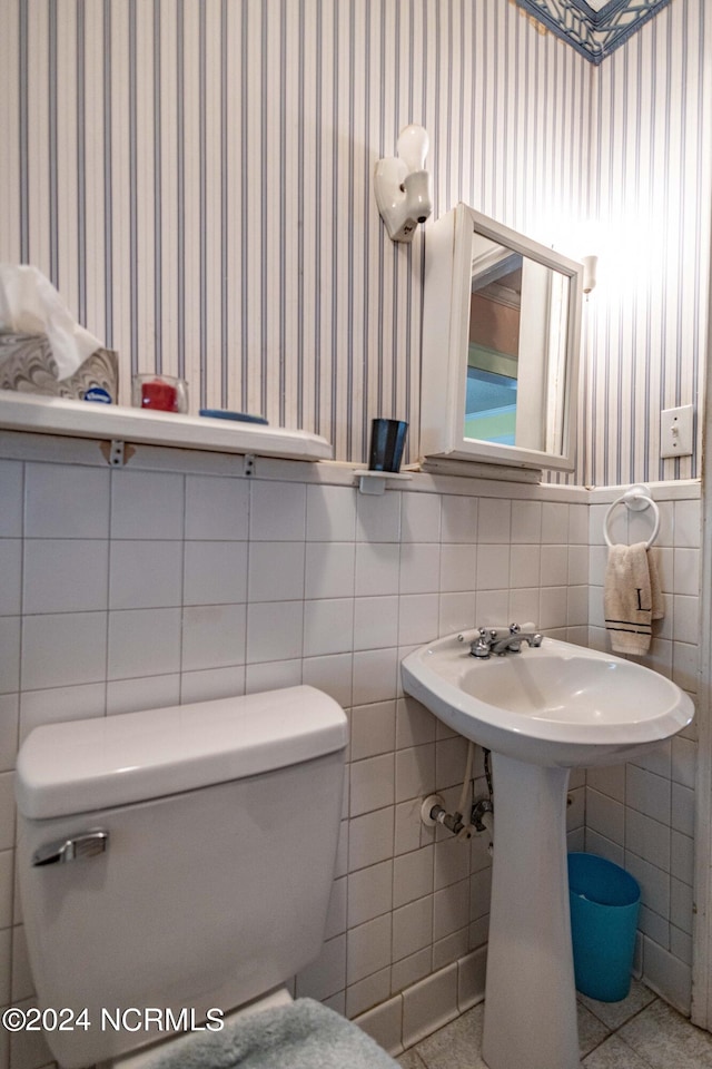 bathroom with toilet, wallpapered walls, and tile patterned floors