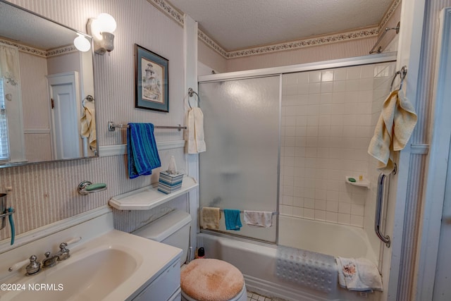 full bathroom with a wainscoted wall, enclosed tub / shower combo, a textured ceiling, vanity, and wallpapered walls