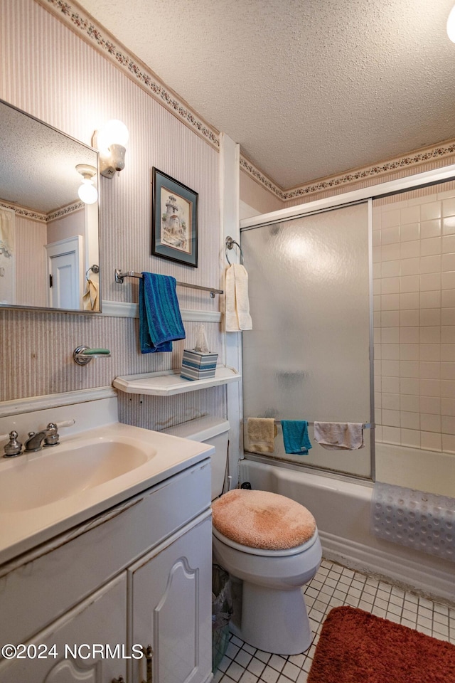 bathroom with a textured ceiling, tile patterned flooring, toilet, and wallpapered walls