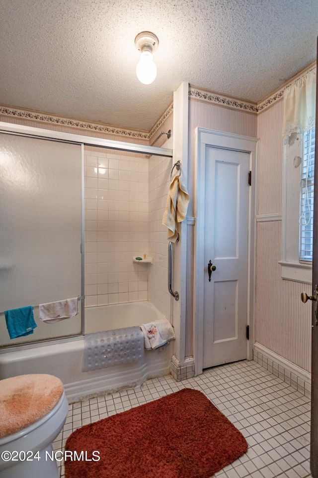 bathroom featuring tile patterned floors, toilet, tub / shower combination, a textured ceiling, and wallpapered walls