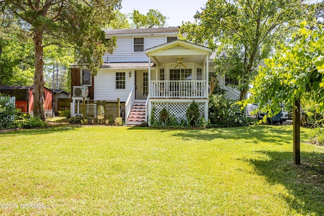 rear view of house featuring a ceiling fan, covered porch, a yard, and stairs