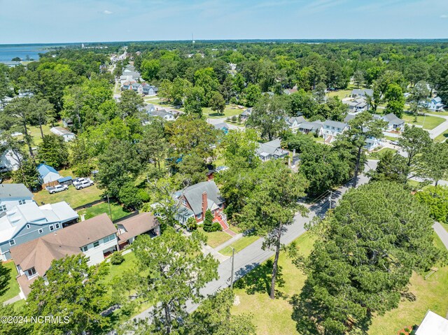 drone / aerial view with a water view, a residential view, and a view of trees