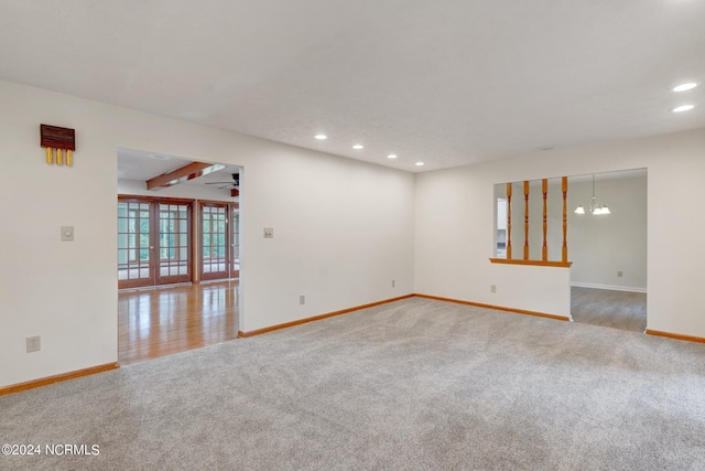 carpeted spare room with beamed ceiling and ceiling fan